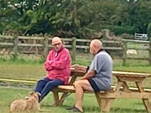 Friends chatting by the lake in the morning sunshine